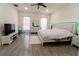 A well-lit main bedroom with a ceiling fan, a bed with a jeweled headboard and wood-style flooring at 1430 Tern Ct, Poinciana, FL 34759