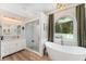 Bright bathroom features a soaking tub, a glass-enclosed shower and a marble-top vanity at 1610 Sherwood Lakes Blvd, Lakeland, FL 33809