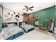 Charming bedroom features two twin beds with plush bedding and a playful dinosaur-themed decor at 1610 Sherwood Lakes Blvd, Lakeland, FL 33809