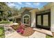 Close-up of home's entrance, featuring a colorful flowerbed, a well-manicured lawn and a paved walkway at 1610 Sherwood Lakes Blvd, Lakeland, FL 33809