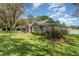 Beautifully landscaped yard with mature trees, shrubs, and green grass surrounding a charming one-story house at 1610 Sherwood Lakes Blvd, Lakeland, FL 33809