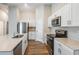 Bright kitchen featuring stainless steel appliances, white cabinetry, and quartz countertops at 4011 Gardenia Ave, Lake Hamilton, FL 33851