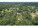 Aerial view of house surrounded by lush greenery, with neighborhood in the background at 5080 Maple Dr, Lakeland, FL 33810