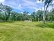 Large, green backyard featuring partial fencing, wooded area, and a storage shed at 5080 Maple Dr, Lakeland, FL 33810