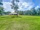 Large grassy backyard provides ample space for recreation and features mature trees for shade and privacy at 5080 Maple Dr, Lakeland, FL 33810