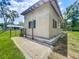 Side view of a barn featuring a stone foundation, shuttered windows, and a gated entrance at 5080 Maple Dr, Lakeland, FL 33810