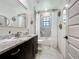 Modern bathroom with a marble countertop vanity, stylish mirrors, and tiled shower at 5080 Maple Dr, Lakeland, FL 33810