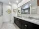 Bathroom featuring a double vanity with marble countertops, black cabinets, and framed mirror at 5080 Maple Dr, Lakeland, FL 33810