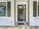Inviting front door with decorative wreath, modern hardware, sidelight, and welcome mat at 5080 Maple Dr, Lakeland, FL 33810
