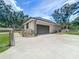 A detached garage with a large driveway and a gated, fenced yard at 5080 Maple Dr, Lakeland, FL 33810