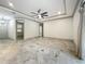 Spacious living room featuring tray ceilings, ceiling fan, and stylish marble flooring at 5080 Maple Dr, Lakeland, FL 33810