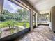 Covered patio with brick pavers and screen offering serene views of the lush green backyard at 5080 Maple Dr, Lakeland, FL 33810