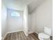 A bathroom with neutral paint, wood-look flooring, toilet, and a shower stall at 5268 Rock Dove Loop, Lakeland, FL 33810