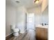 Bright bathroom features modern vanity, toilet and gray wood-look flooring at 5268 Rock Dove Loop, Lakeland, FL 33810