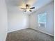This bedroom features neutral walls, brown carpet, ceiling fan, and window unit at 5268 Rock Dove Loop, Lakeland, FL 33810