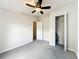 This bedroom features neutral walls, gray carpet, and a ceiling fan with light at 5268 Rock Dove Loop, Lakeland, FL 33810