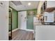 Small kitchen with modern appliances, tile backsplash, light cabinets, and a 