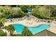 Elevated view of a kidney bean shaped pool with surrounding chairs and tables with blue umbrellas at 6165 Carrier Dr # 1309, Orlando, FL 32819