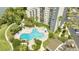Aerial view of a kidney-shaped swimming pool with a hot tub, pool furniture, and landscaped grounds at 6165 Carrier Dr # 1309, Orlando, FL 32819