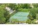 Aerial shot of a community tennis court with a fence, surrounded by lush green trees and landscaping at 6165 Carrier Dr # 1309, Orlando, FL 32819