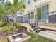 Outdoor living space featuring a fire pit, patio, and lush landscaping with palm trees at 67 Bella Oaks Dr, Port Orange, FL 32129