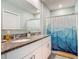 Well-lit bathroom features double sinks, granite countertops, and a stylish shower curtain at 67 Bella Oaks Dr, Port Orange, FL 32129