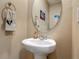 Half bathroom featuring a pedestal sink, neutral paint and round mirror at 67 Bella Oaks Dr, Port Orange, FL 32129