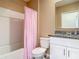 Bathroom with bathtub, shower with pink curtain, toilet, granite countertop, and vanity at 67 Bella Oaks Dr, Port Orange, FL 32129