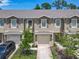 View of townhomes featuring attached garages, neutral colors, and well-maintained landscaping at 67 Bella Oaks Dr, Port Orange, FL 32129