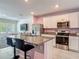 Kitchen with white cabinets, stainless appliances, granite counters and breakfast bar seating at 67 Bella Oaks Dr, Port Orange, FL 32129