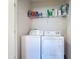 Functional laundry room featuring a washer, dryer, and overhead storage shelf at 67 Bella Oaks Dr, Port Orange, FL 32129