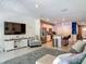 Open-concept living room with a gray rug, stainless steel appliances, bar seating, and a television at 67 Bella Oaks Dr, Port Orange, FL 32129
