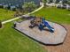 Community playground featuring a slide and climbing structure set on a mulch base with benches and picnic table nearby at 67 Bella Oaks Dr, Port Orange, FL 32129