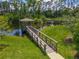 Scenic pond with a wooden dock and gazebo, surrounded by lush greenery and trees at 67 Bella Oaks Dr, Port Orange, FL 32129