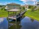 Picturesque pond featuring a wooden dock and gazebo, reflecting the surrounding buildings and sky at 67 Bella Oaks Dr, Port Orange, FL 32129