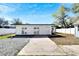A view of the home's backyard, featuring a white exterior, stone foundation, and French doors at 1616 Huntington St, Lakeland, FL 33801