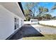Backyard featuring French doors opening to the patio, shed, and white fencing for privacy at 1616 Huntington St, Lakeland, FL 33801