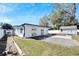 A pleasant backyard featuring an outdoor shed, green grass, and a white fence at 1616 Huntington St, Lakeland, FL 33801