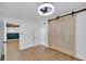 Well-lit bedroom featuring barn door closet and open entry to the hall and adjacent room at 1616 Huntington St, Lakeland, FL 33801
