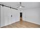 Bedroom boasts a ceiling fan, wood-look floors and unique sliding closet door at 1616 Huntington St, Lakeland, FL 33801