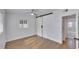 A bedroom features light hardwood floors, a ceiling fan, and a sliding barn door closet at 1616 Huntington St, Lakeland, FL 33801