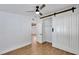 Bedroom featuring neutral walls, wood-look flooring, ceiling fan, and a sliding barn door at 1616 Huntington St, Lakeland, FL 33801