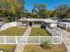 Charming home with a well-manicured lawn, white picket fence, and inviting walkway at 1616 Huntington St, Lakeland, FL 33801
