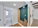 Hallway with wood floors and designer accent wall leads to the remodeled bathroom at 1616 Huntington St, Lakeland, FL 33801