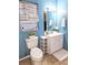 Cozy bathroom featuring blue walls, a window with patterned curtains and white vanity with storage at 1841 Talmadge St, Deland, FL 32724