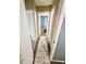 Hallway with neutral carpet, white trim, doors, a safety gate and good lighting at 1841 Talmadge St, Deland, FL 32724