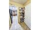 Walk-in pantry with shelving and tiled floor, adjacent to the refrigerator and eat-in dining area at 1841 Talmadge St, Deland, FL 32724
