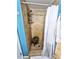 Tiled walk-in shower with a teak corner stool, convenient shelving, and a neutral shower curtain at 1841 Talmadge St, Deland, FL 32724