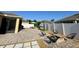Brick paver patio, fire pit, chairs, outdoor dining set with privacy hedge and white fence at 2864 Running Brook Cir, Kissimmee, FL 34744