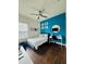 Stylish bedroom with a bright blue accent wall and modern decor with wood floor at 2864 Running Brook Cir, Kissimmee, FL 34744